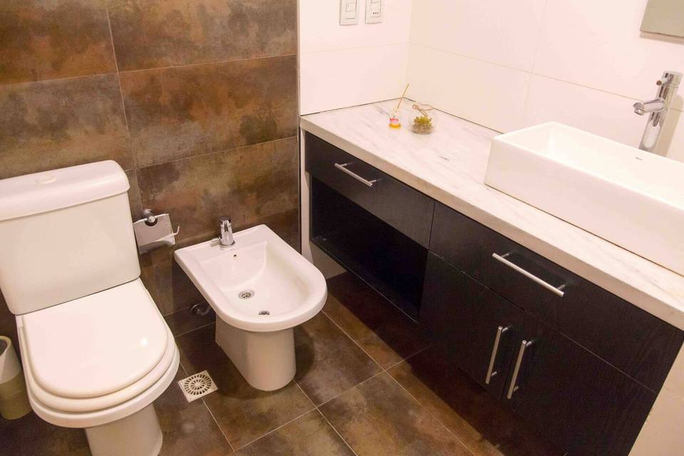 Casa de banho com sanita, bidet e móvel escuro