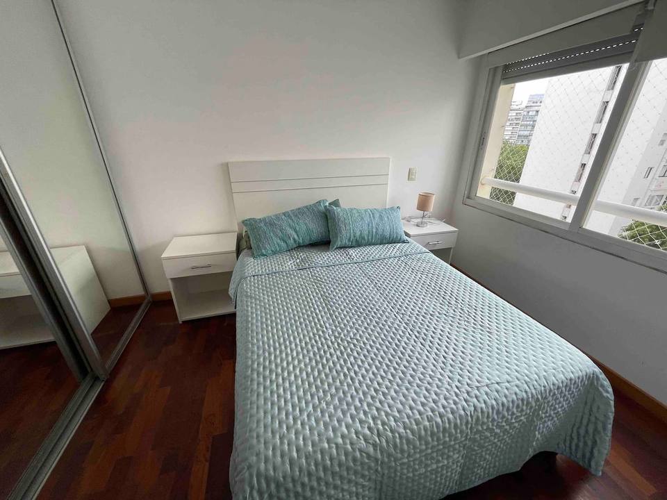 Quarto luminoso com cama de casal e roupeiro espelhado