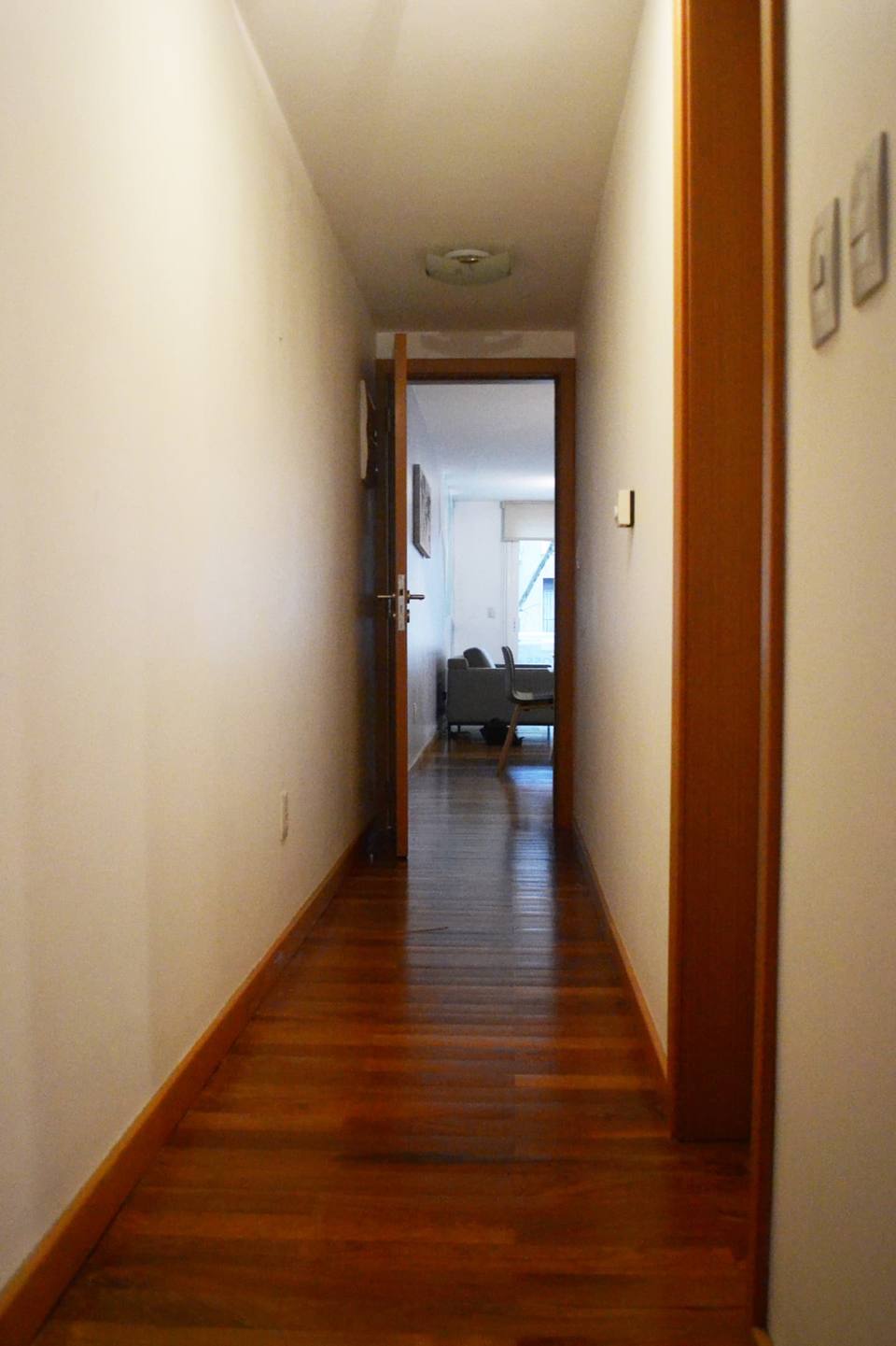 Corredor com piso de madeira para a sala