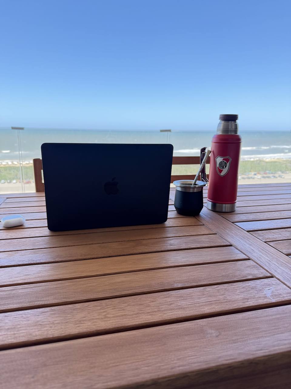Laptop, mate, thermos on outdoor table