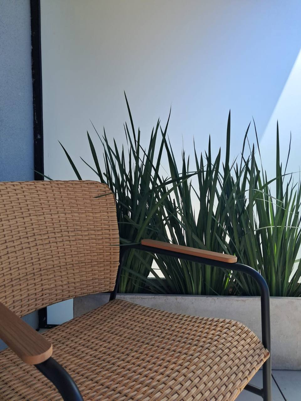 Wicker chair on balcony with plants
