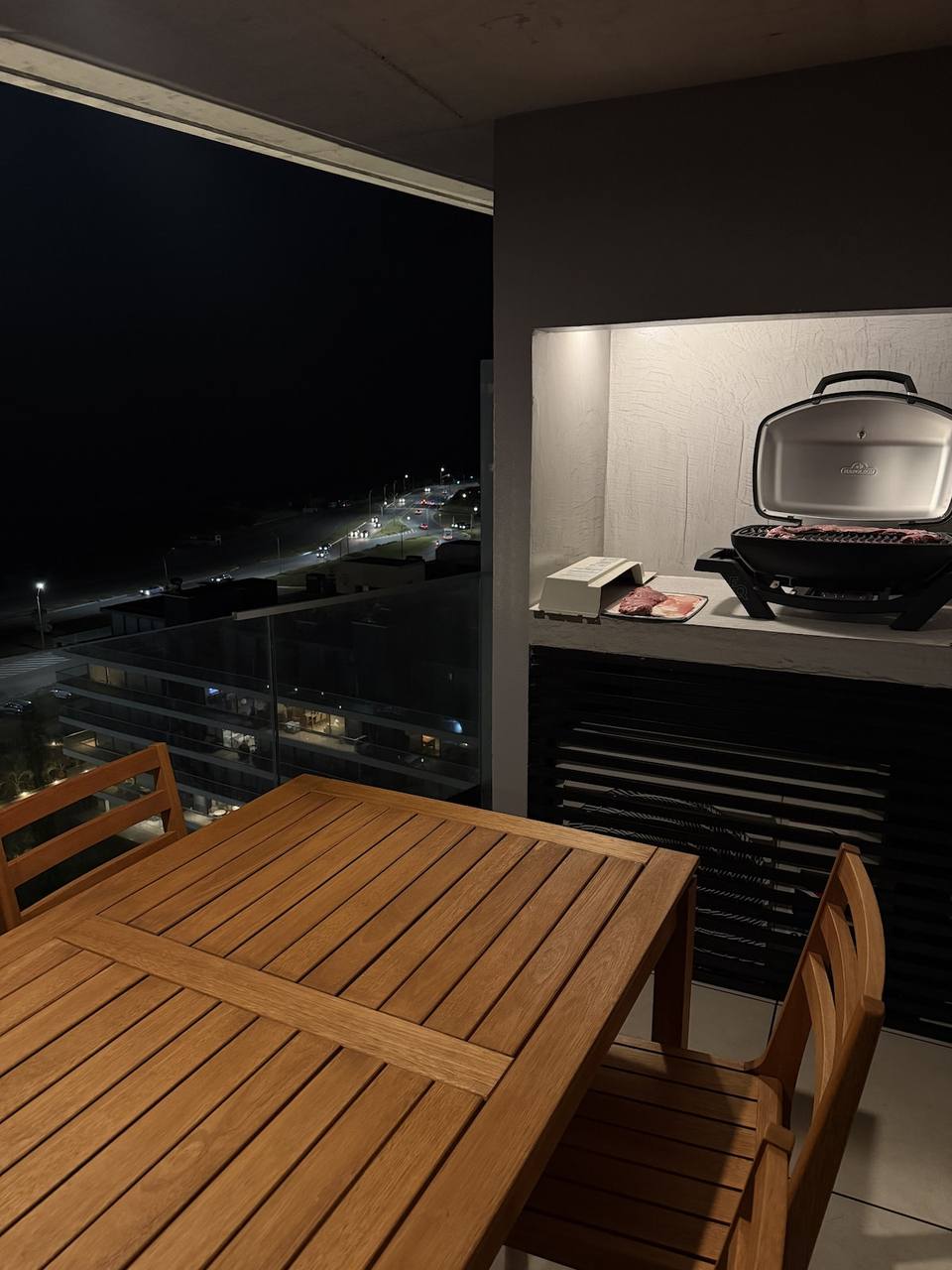 Balcony with table, chairs, and grill