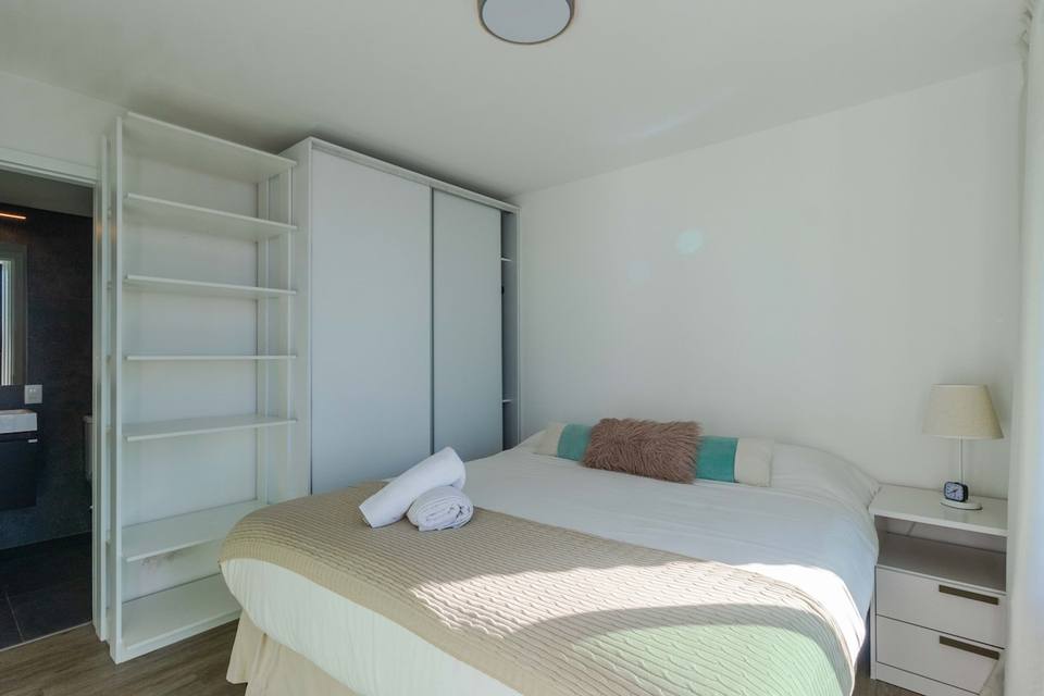 Cama de casal, roupeiro e prateleiras, muito luminoso
