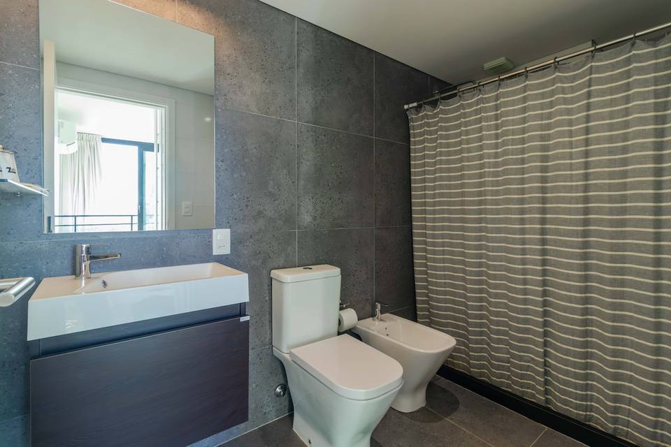 Casa de banho com móvel de lavatório, sanita, bidet e cortina de duche