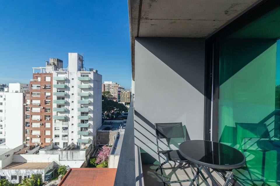 Varanda com cadeiras, mesinha e vista para edifícios de Pocitos