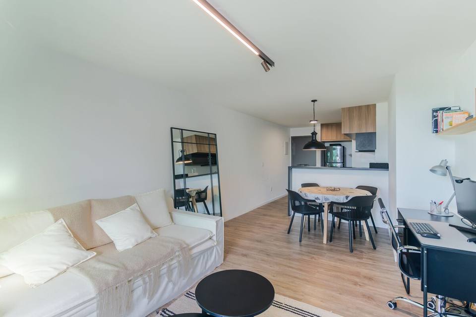 Sala de estar e jantar com cozinha integrada e espelho de pé