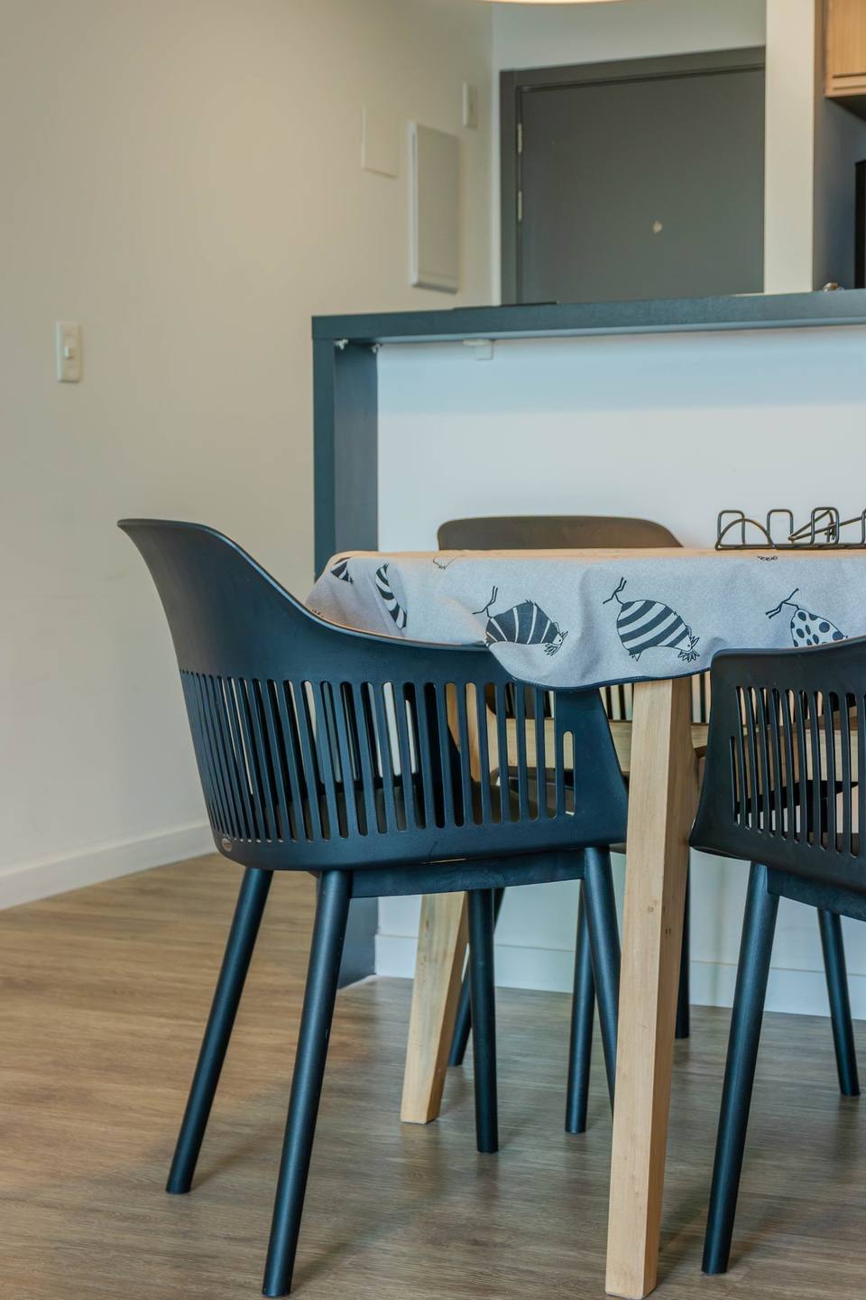 Detalhe de cadeiras e mesa de jantar com atoalhados