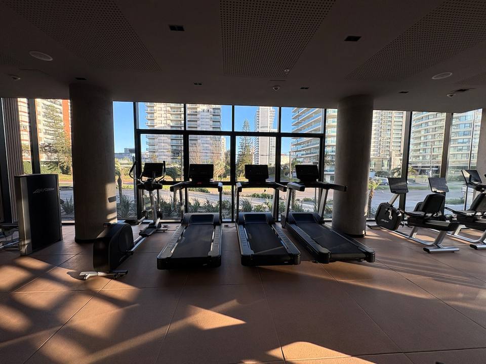 Gimnasio con máquinas de cardio y ventanales