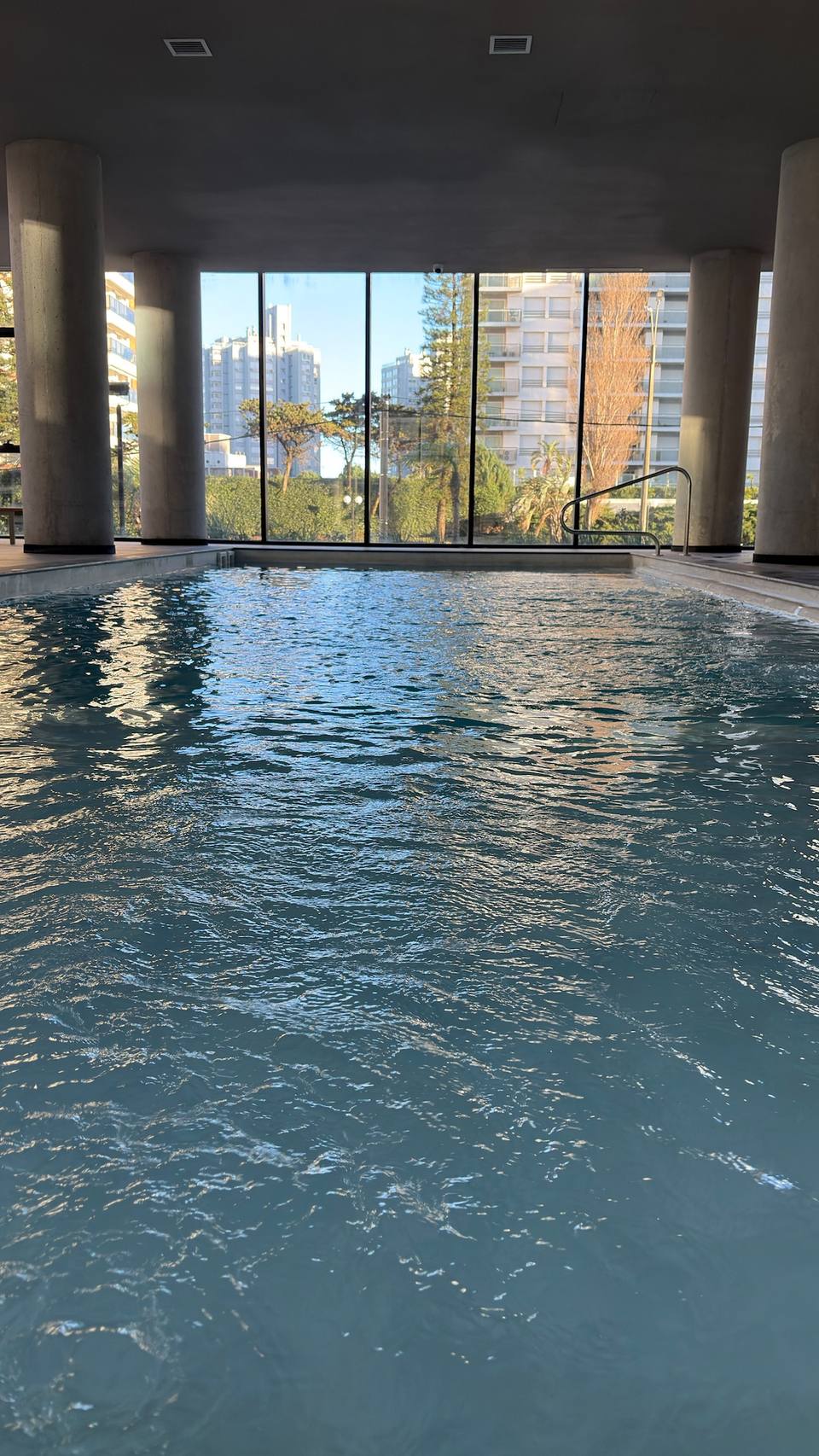 Piscina cubierta con ventanales y vista urbana