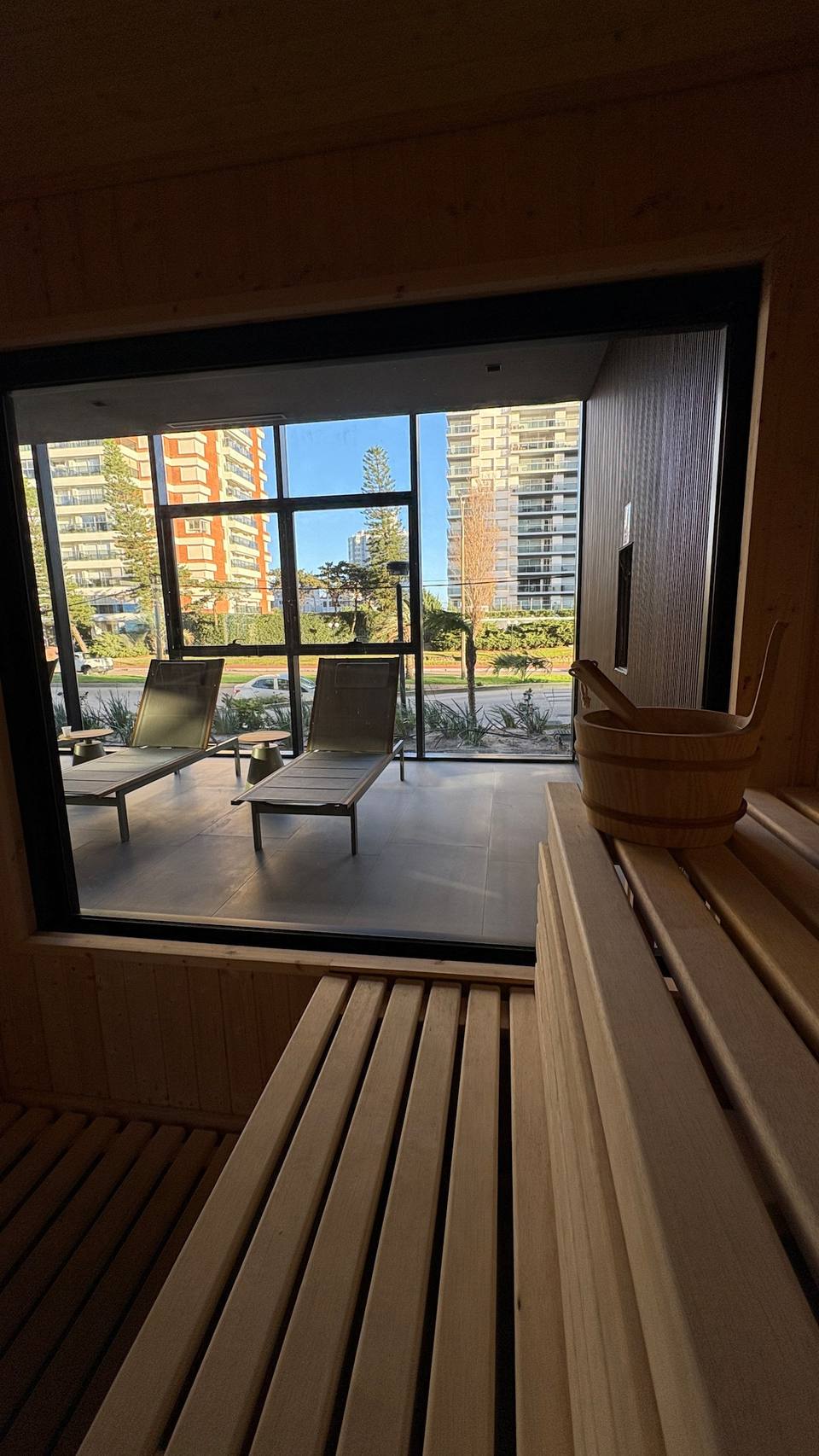 Sauna con ventana al exterior, tumbonas