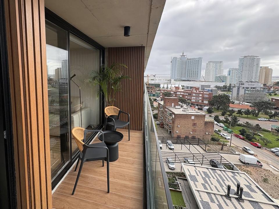 Balcón con sillas, mesa y vista ciudad