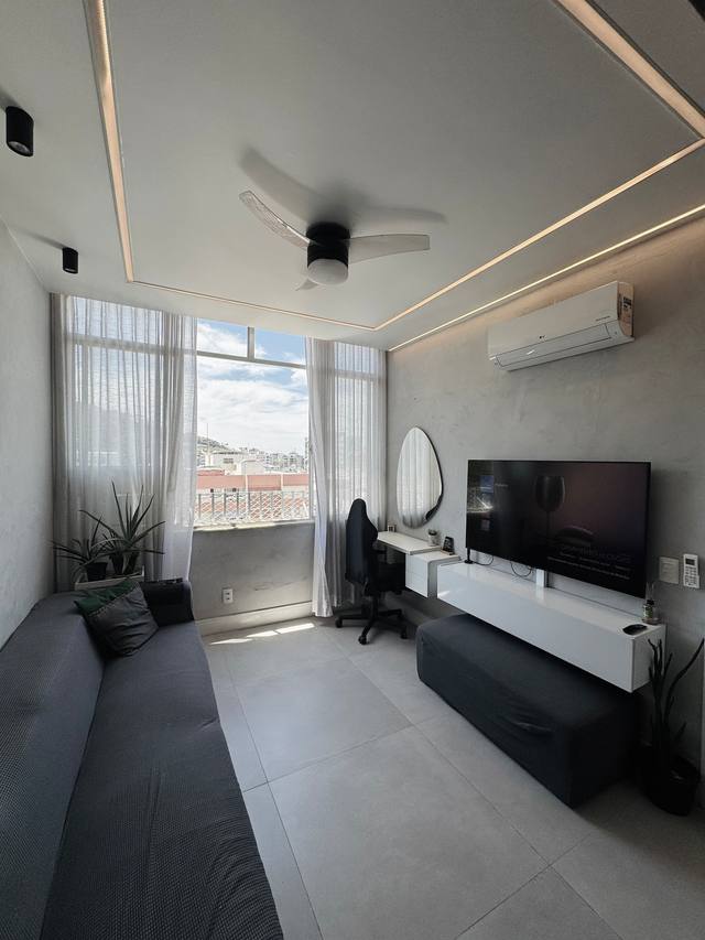 Sala luminosa com grande janelão e zona de trabalho