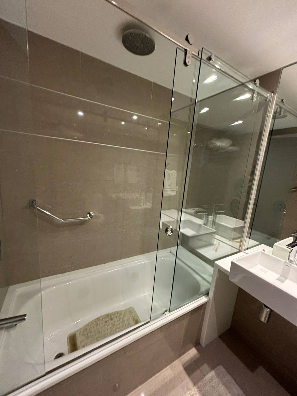 Bathtub with glass shower screen and faucet.