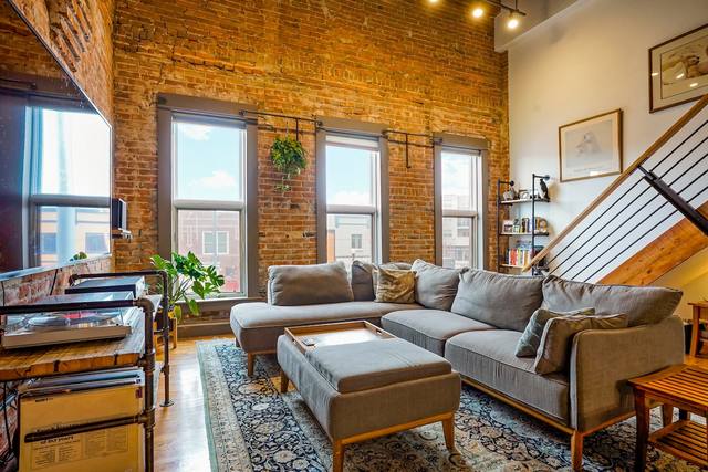 Spacious living room with double-height ceilings and exposed brick