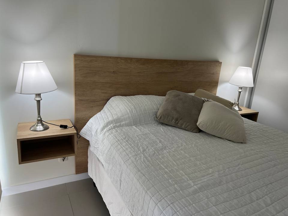 Cama con cabecero, mesas de noche y lámparas