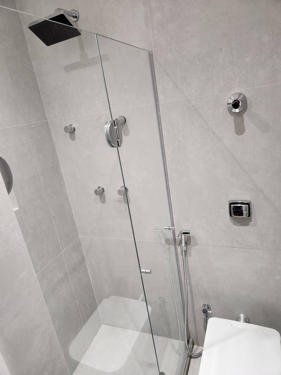 Casa de banho moderna com acabamentos em pedra e vidro