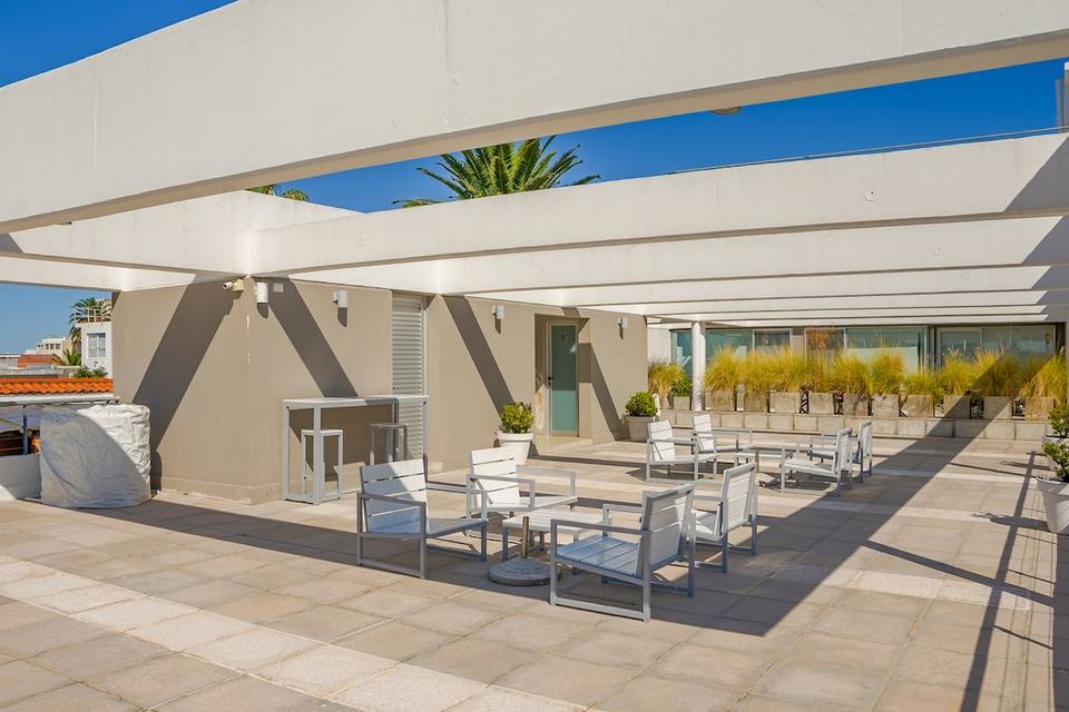 Terraza exterior con muebles, pérgola y plantas