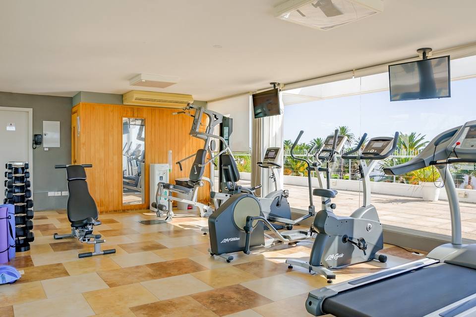 Gimnasio con máquinas de ejercicio y ventanales
