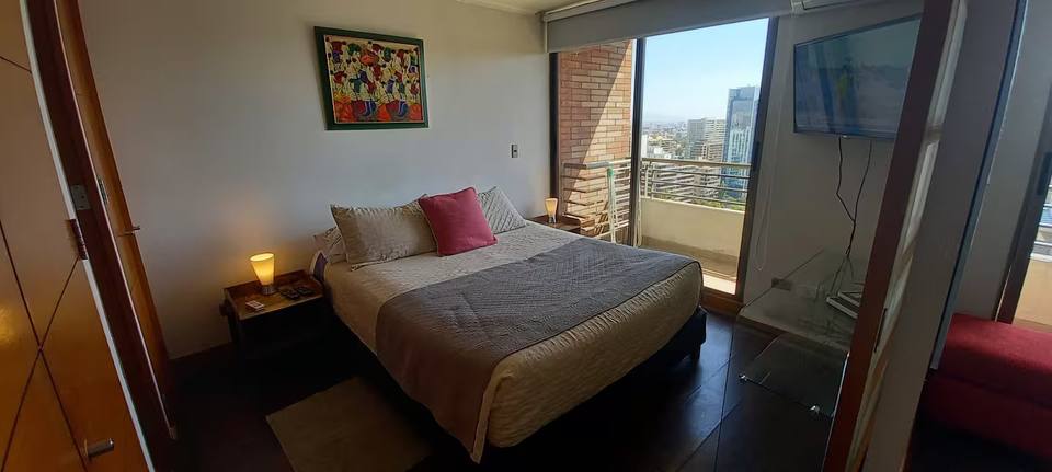 Quarto com cama de casal e saída para a varanda