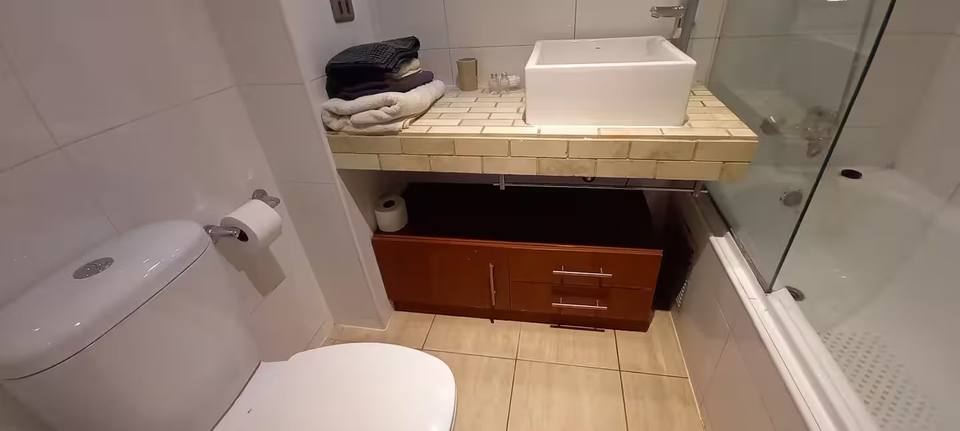 Casa de banho com banheira e resguardo de vidro
